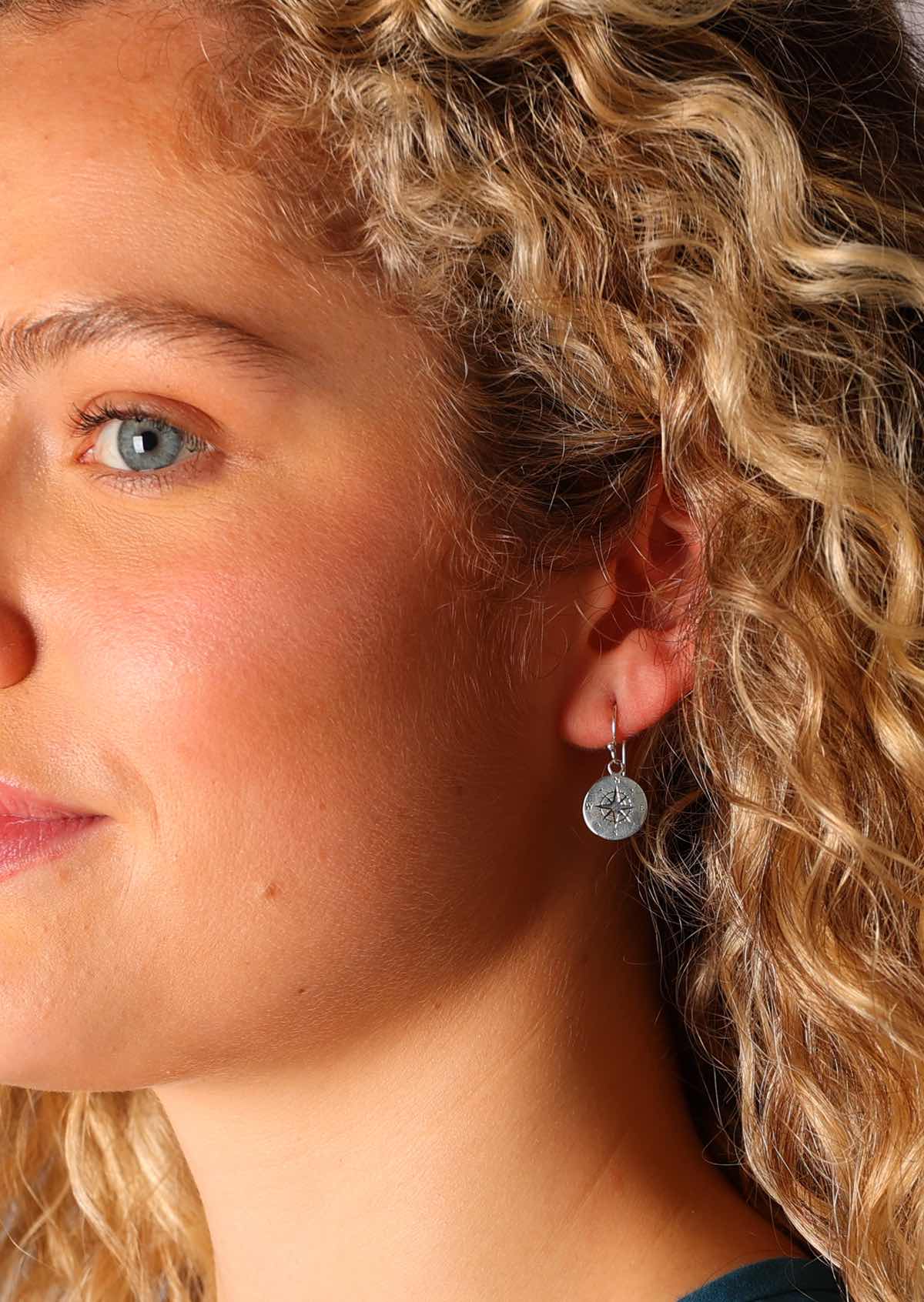Sterling silver compass earrings suspended on a wire hook