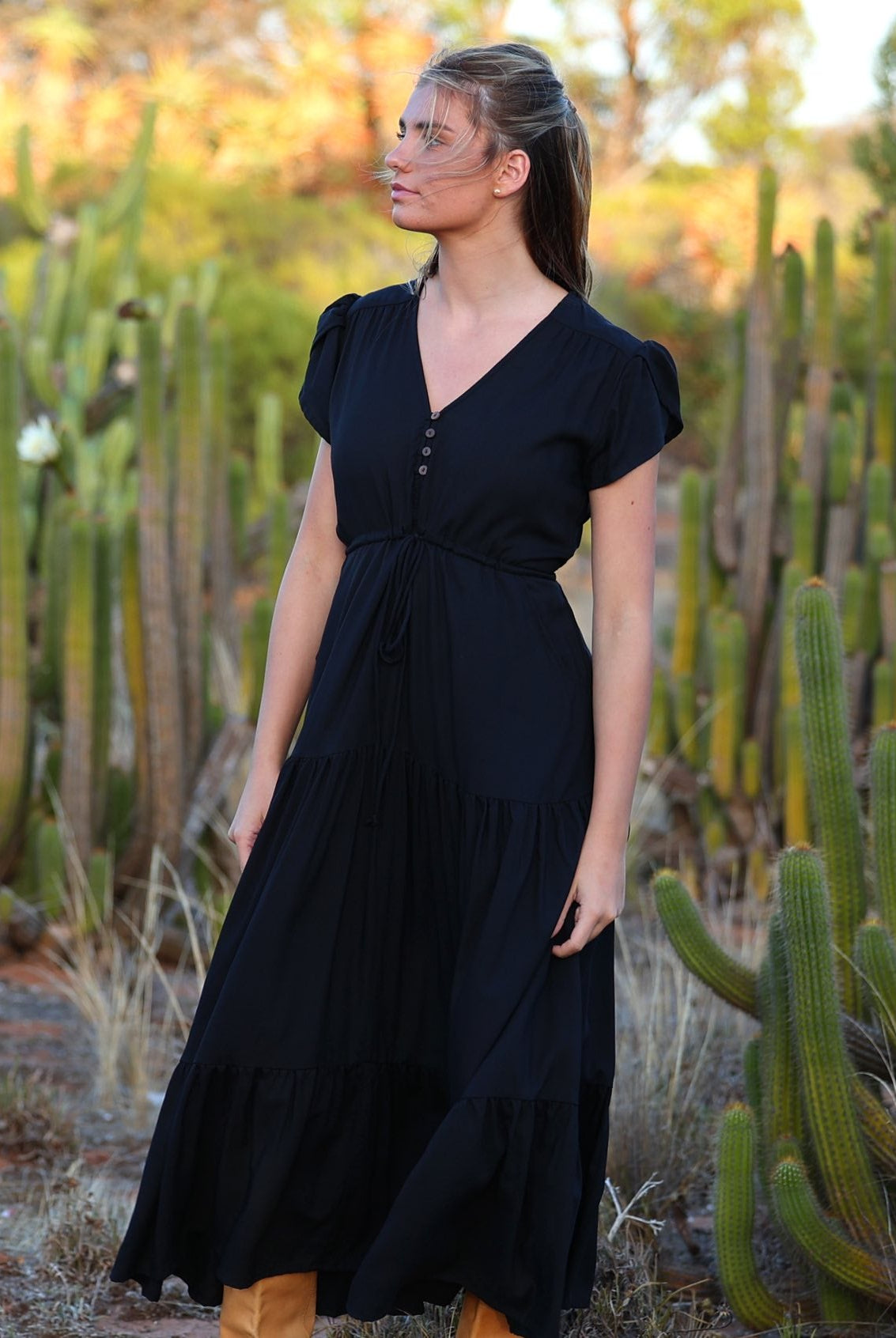 Model wears black rayon maxi dress with tiered, voluminous skirt and elasticised waistband
