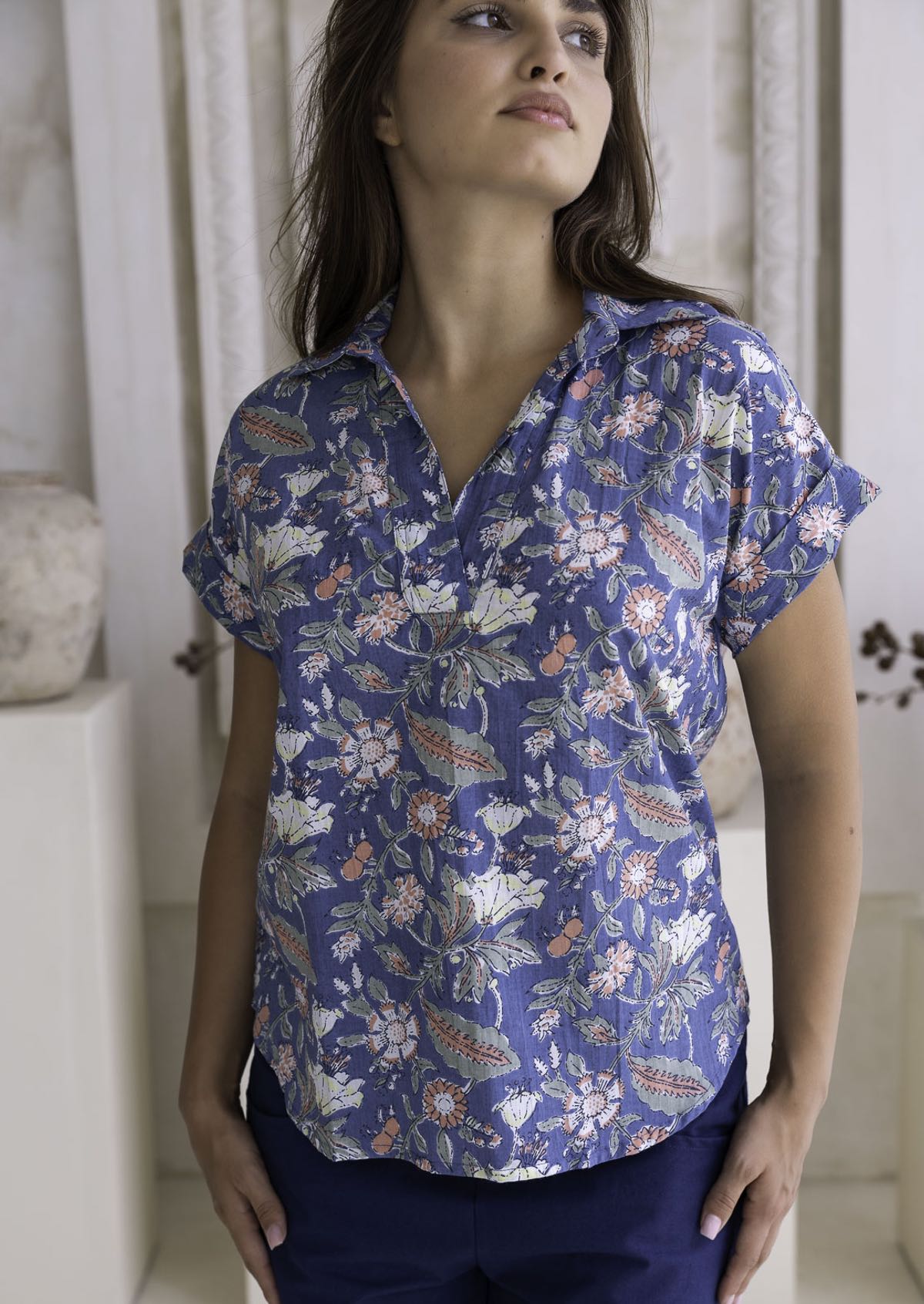 100 percent cotton relaxed fit dusty blue based floral top with short folded cuff sleeves, collar and V neckline