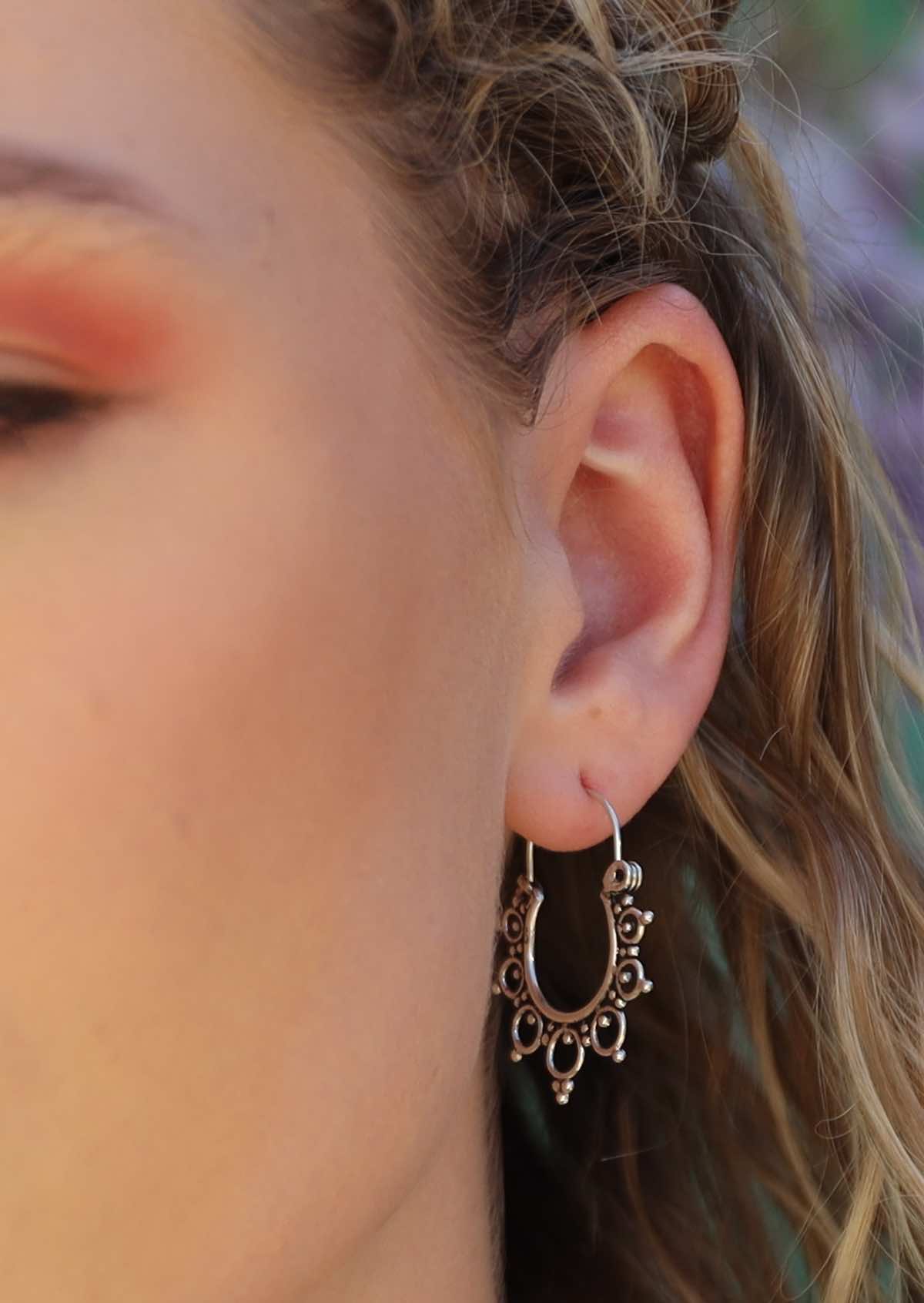 close up of woman wearing boho silver hoop earrings