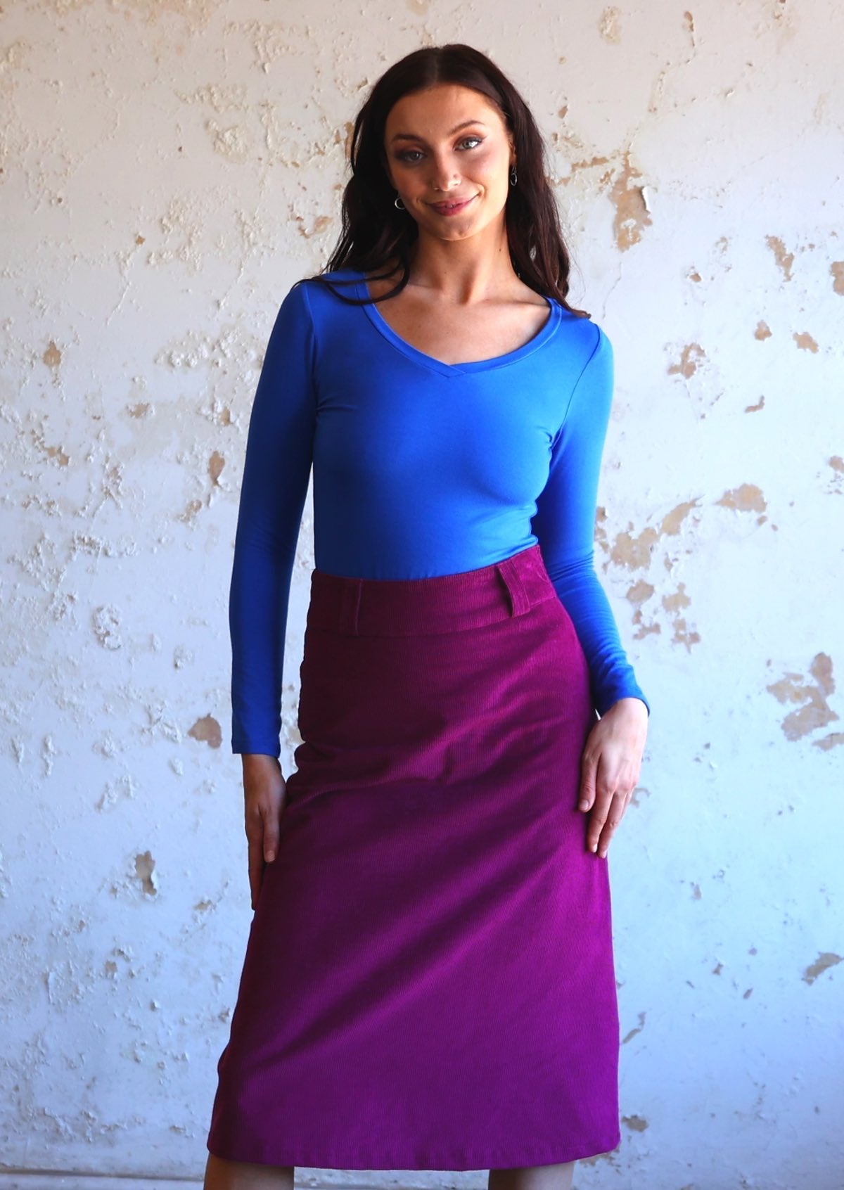 woman wearing purple corduroy aline skirt with bright blue long sleeve top
