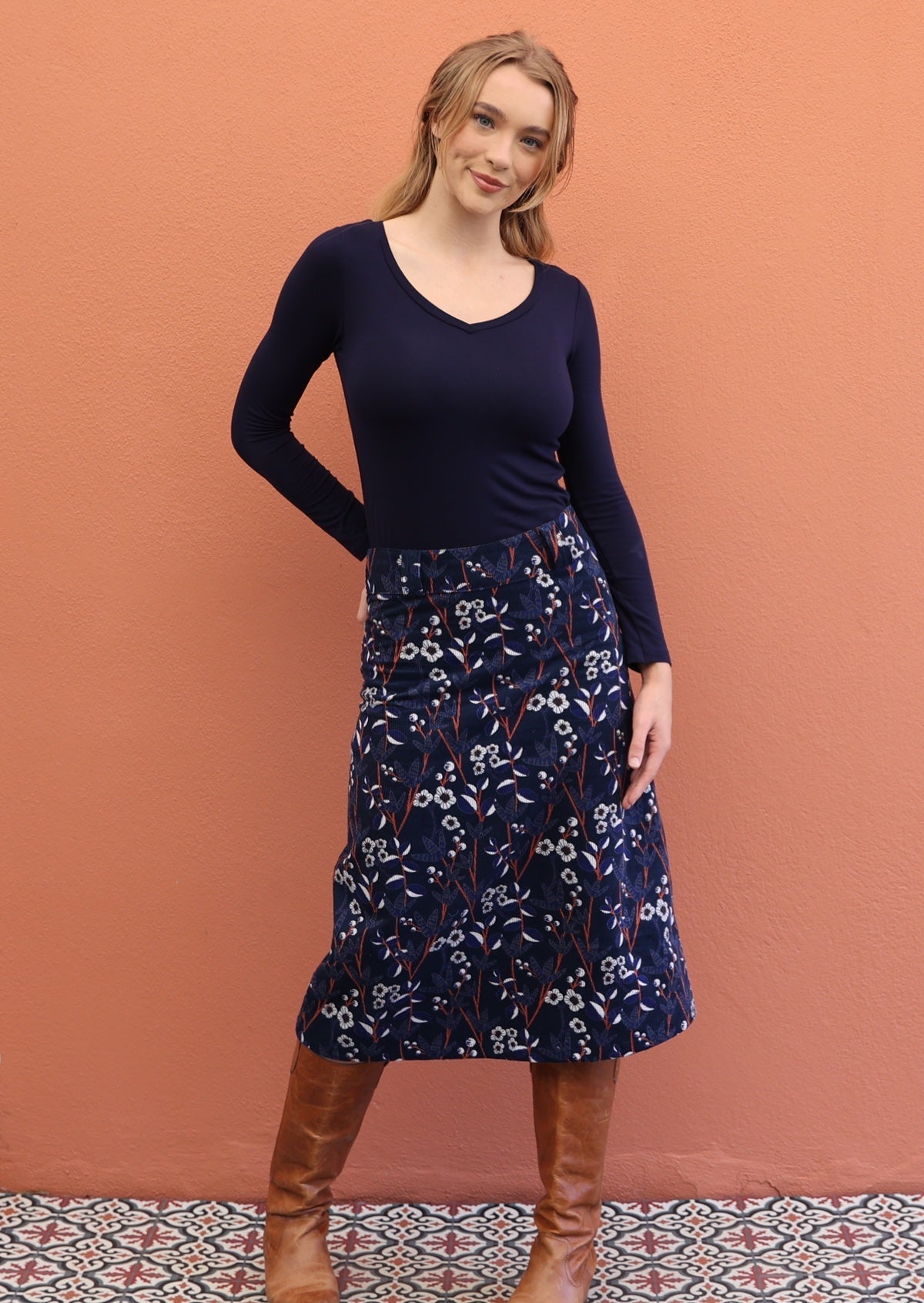 Woman wearing gorgeous floral printed cotton corduroy skirt with side zip and belt loops.