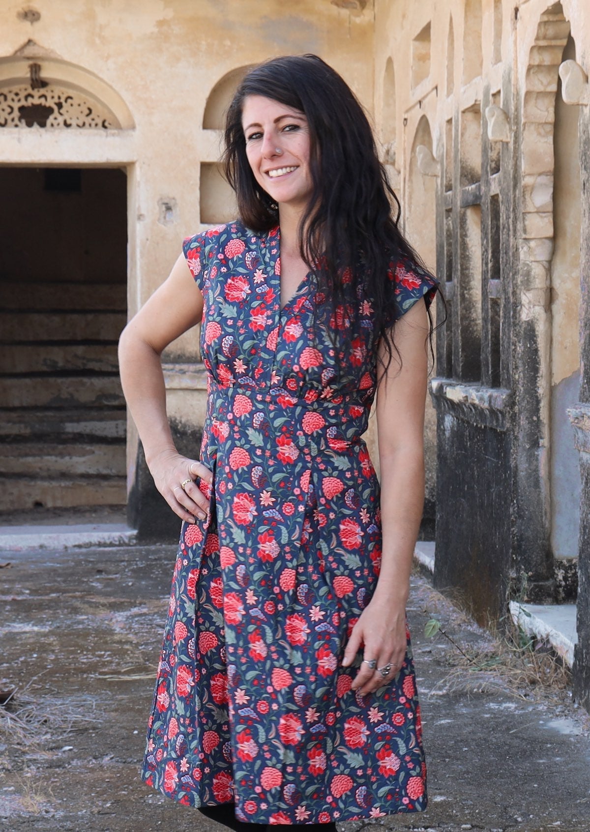 Model with hand on hip wearing deep navy blue based floral cotton retro style dress with cap sleeves