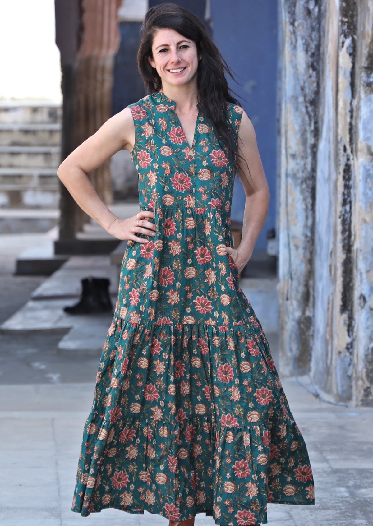 Model wearing green floral printed dress with buttoned bodice and mandarin collar forming V neckline.