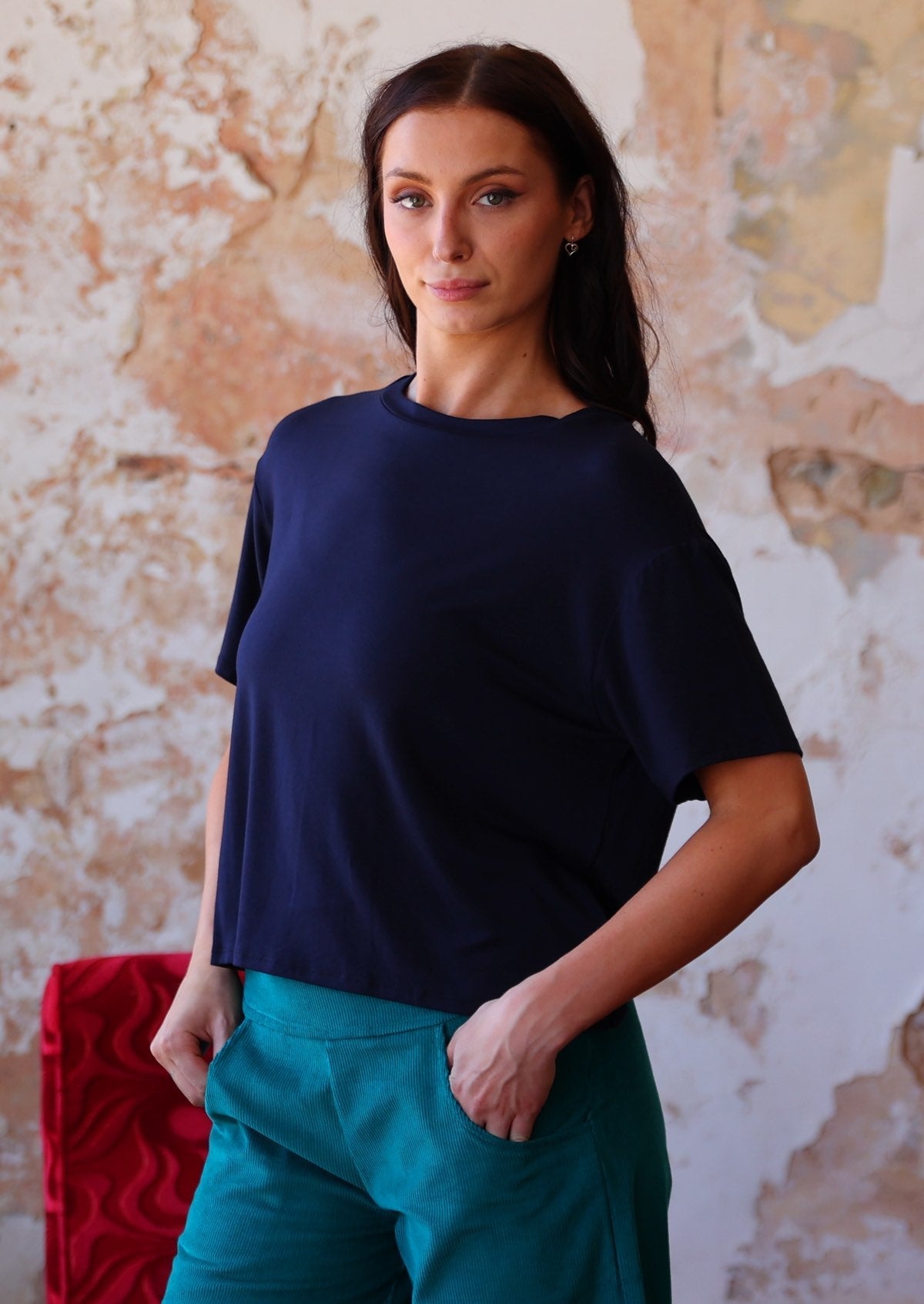 woman in navy blue rayon loose fit t-shirt over teal corduroy pants