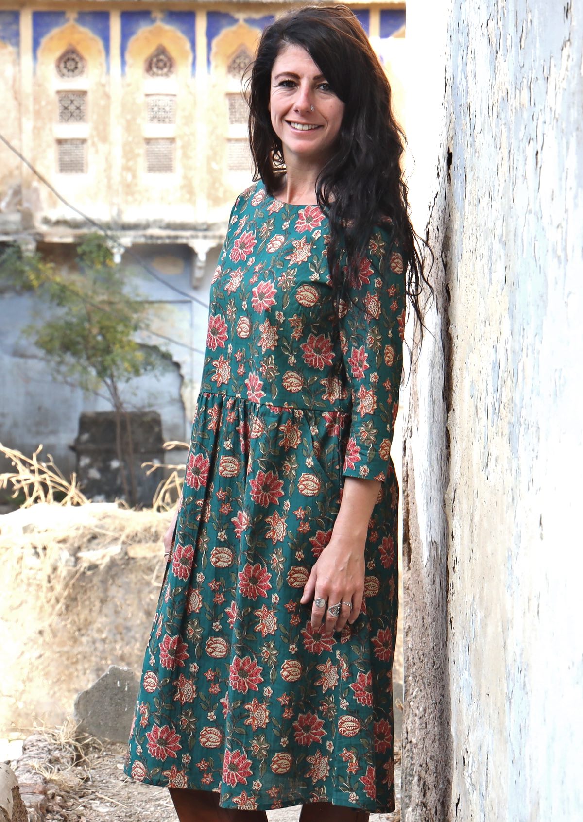 Model wears over a knee length cotton dress with pockets and wide round neckline.