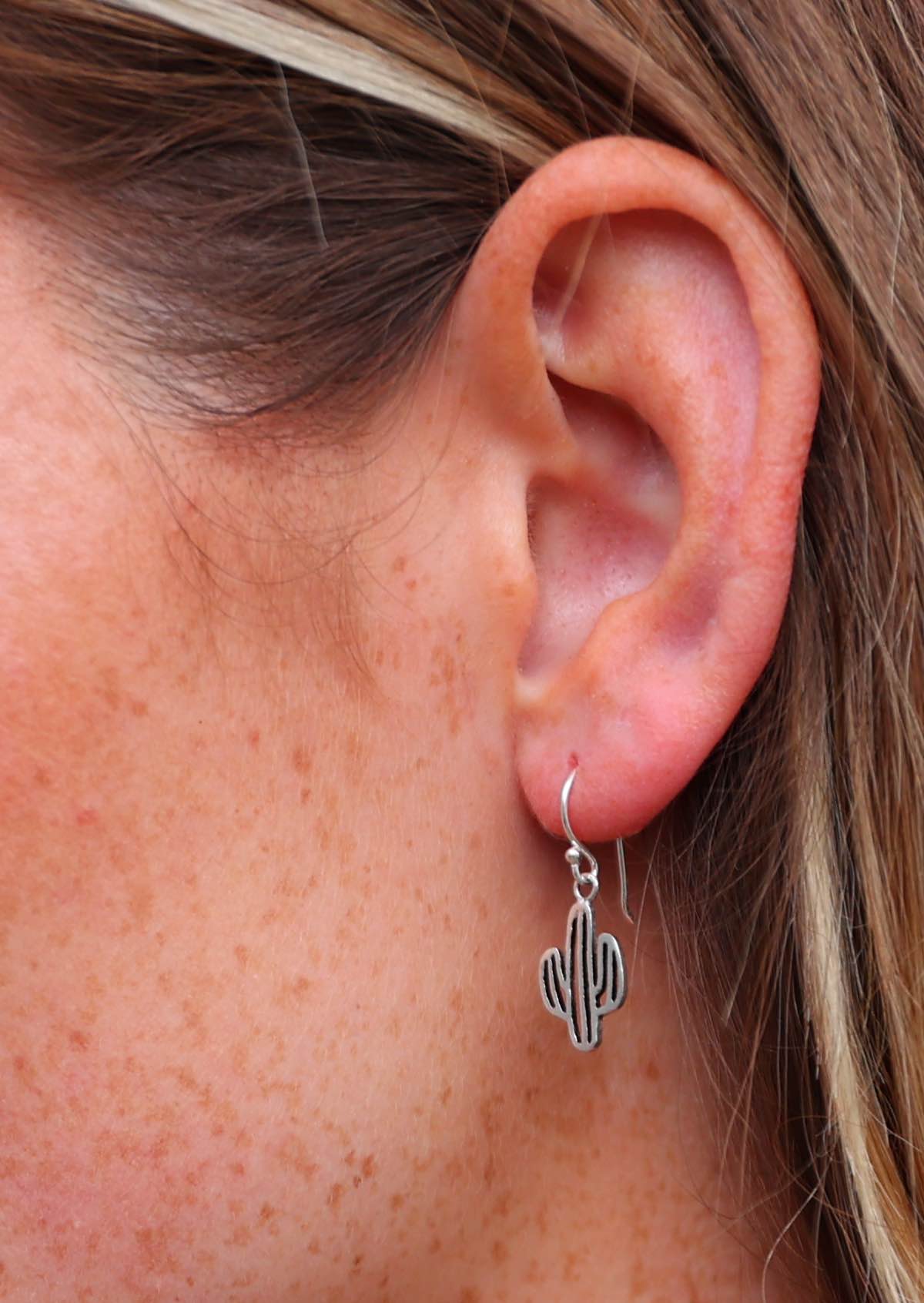 Close up of silver cactus earring suspended from wire hook