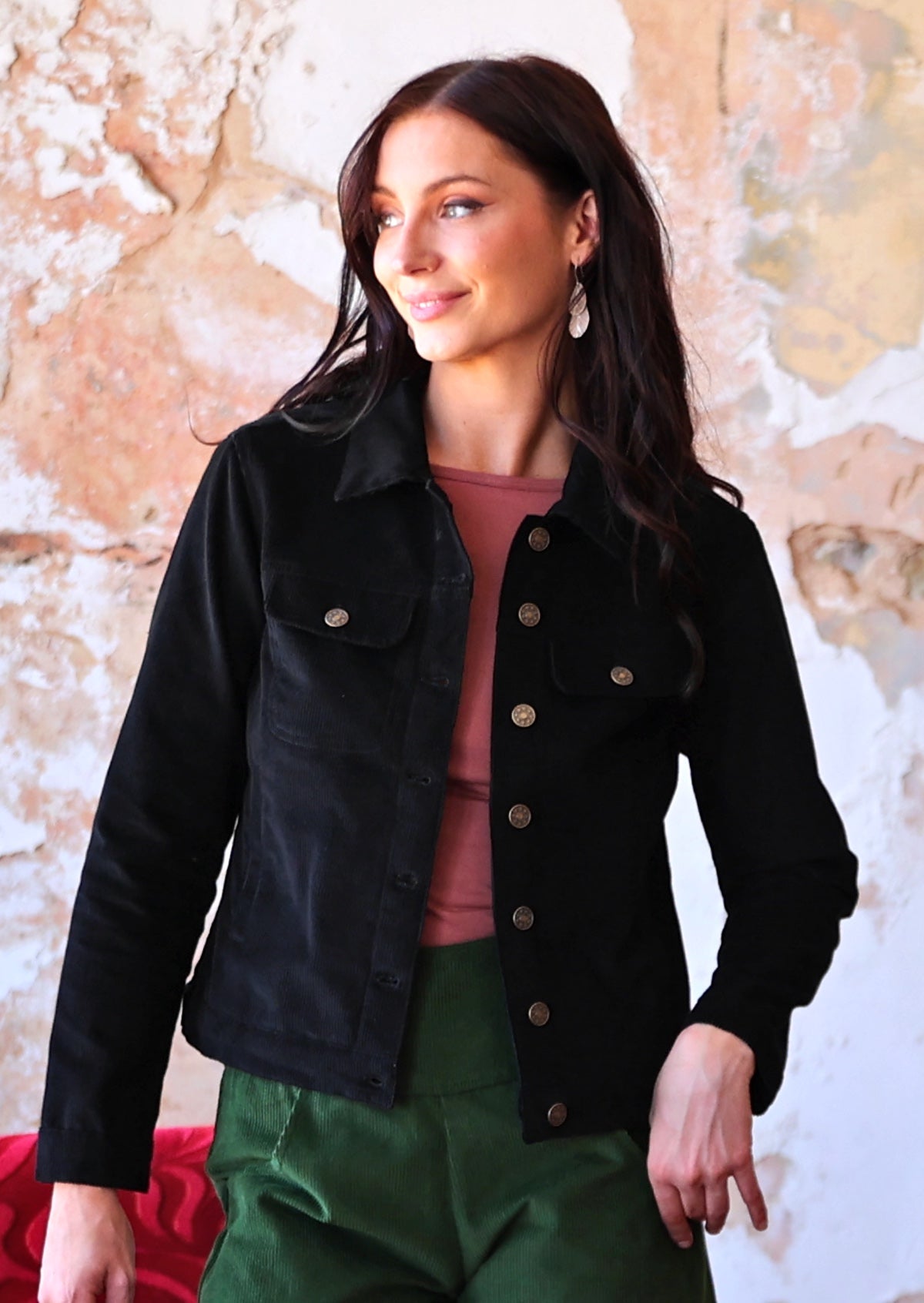 Woman wearing long sleeve cotton corduroy jacket with brass buttons
