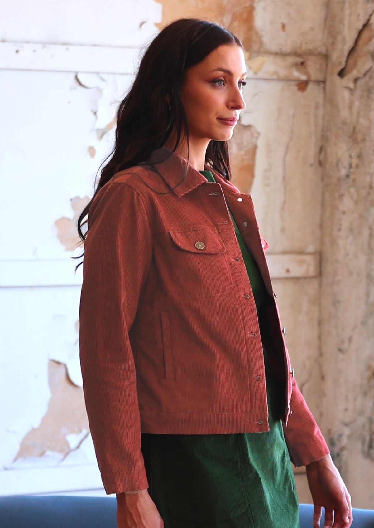 Woman in rust coloured cotton corduroy jacket with front pockets