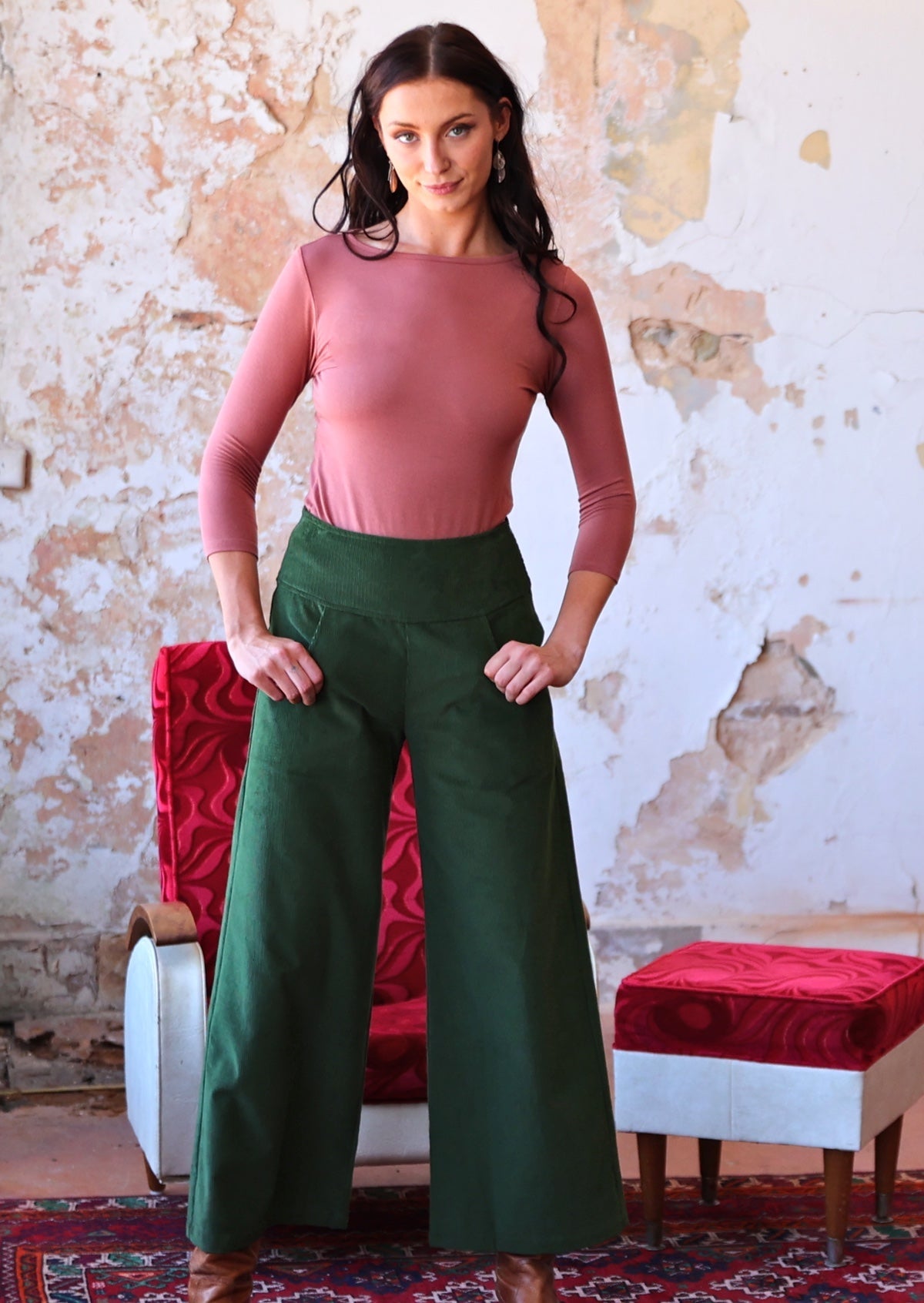 olive green wide leg corduroy pants on woman with pink top and dark hair