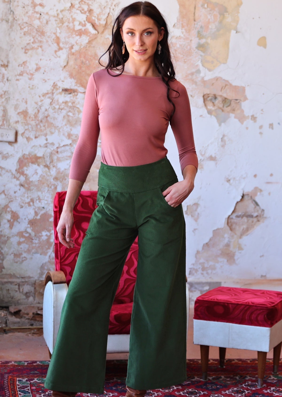 woman wearing long sleeve pink boat neck top and green corduroy pants
