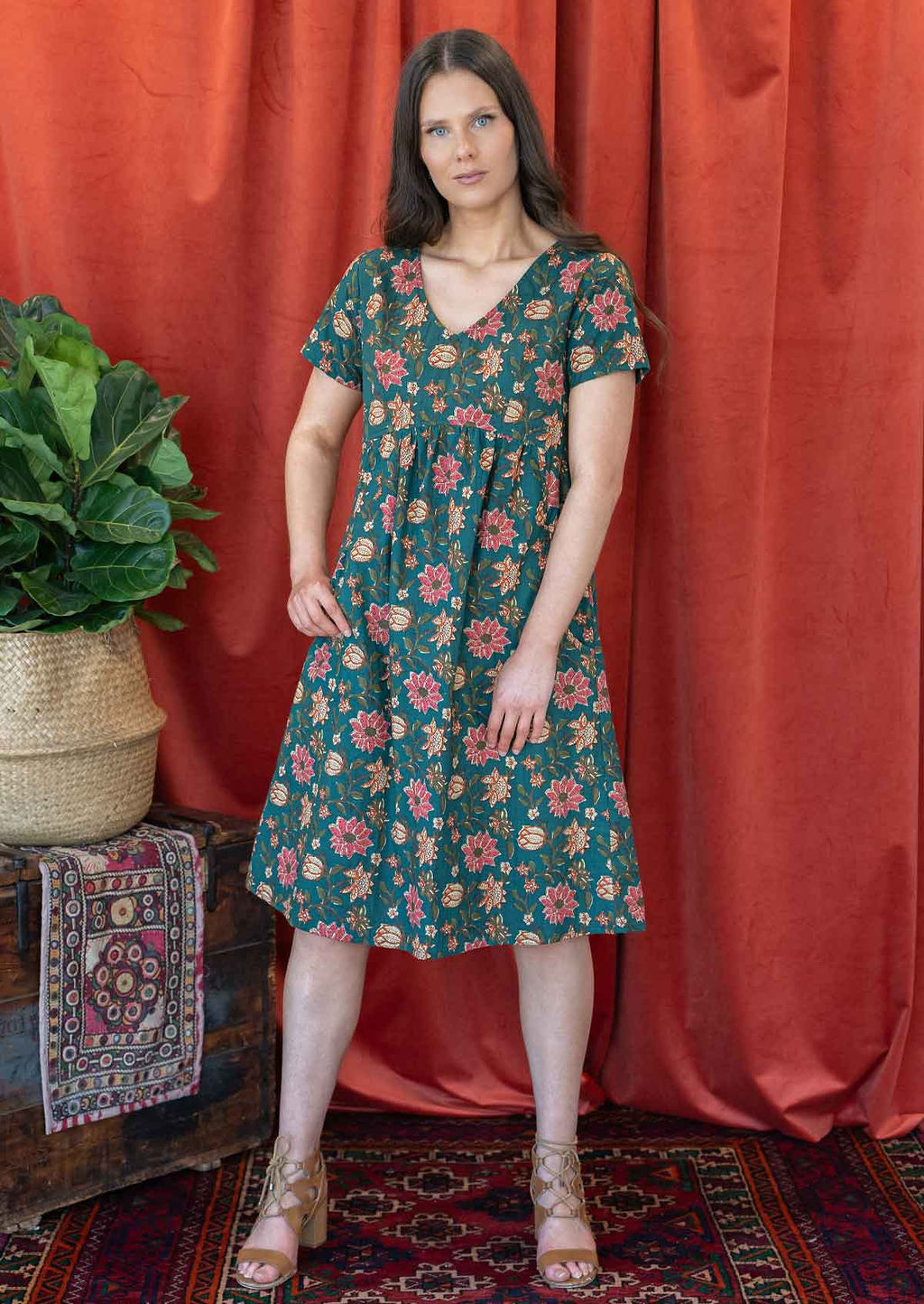 Model wearing a cotton knee length dress with empire waist, short sleeves and pockets.