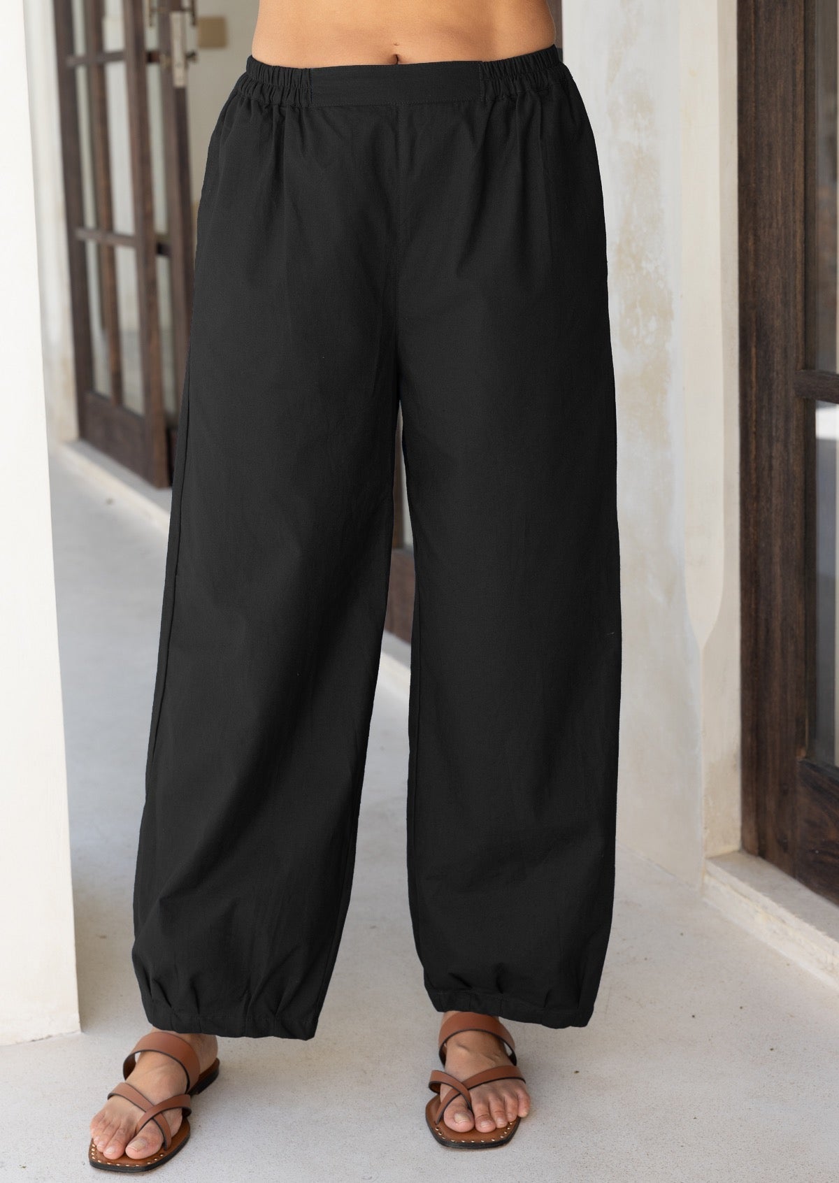 Close up of pants showing the elastic either side of the waistband and the small pleats that taper the ankle in slightly