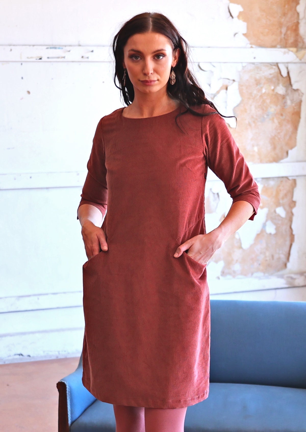 Woman in long sleeve rust coloured corduroy tunic with pockets