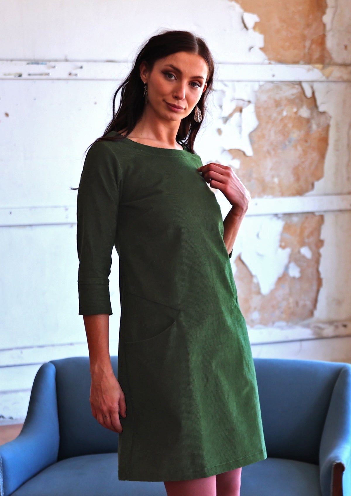 Woman wearing green corduroy A-line dress with 3/4 sleeves