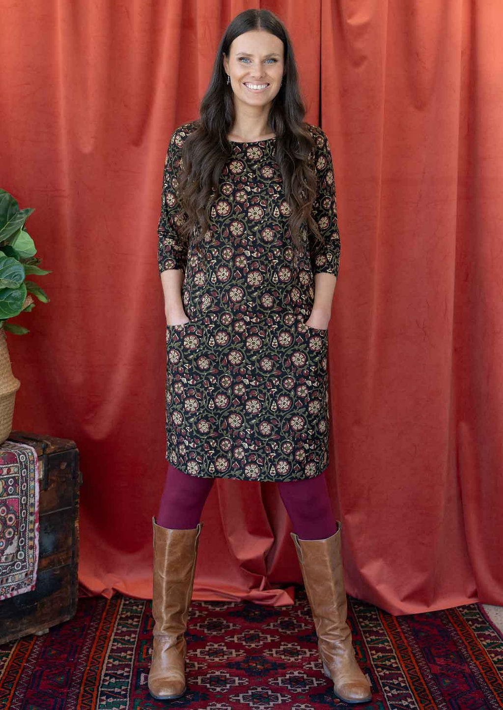 Model wearing floral printed cotton dress in black base with maroon leggings.