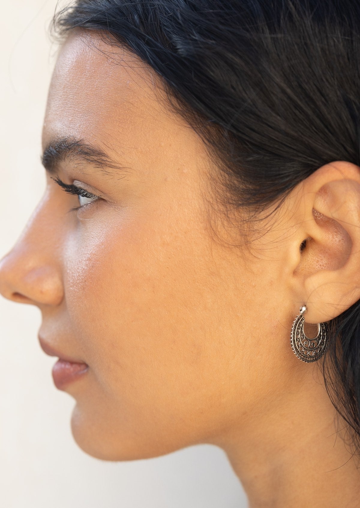 Close-up of a woman wearing a sterling silver mandala earring with a clip closure