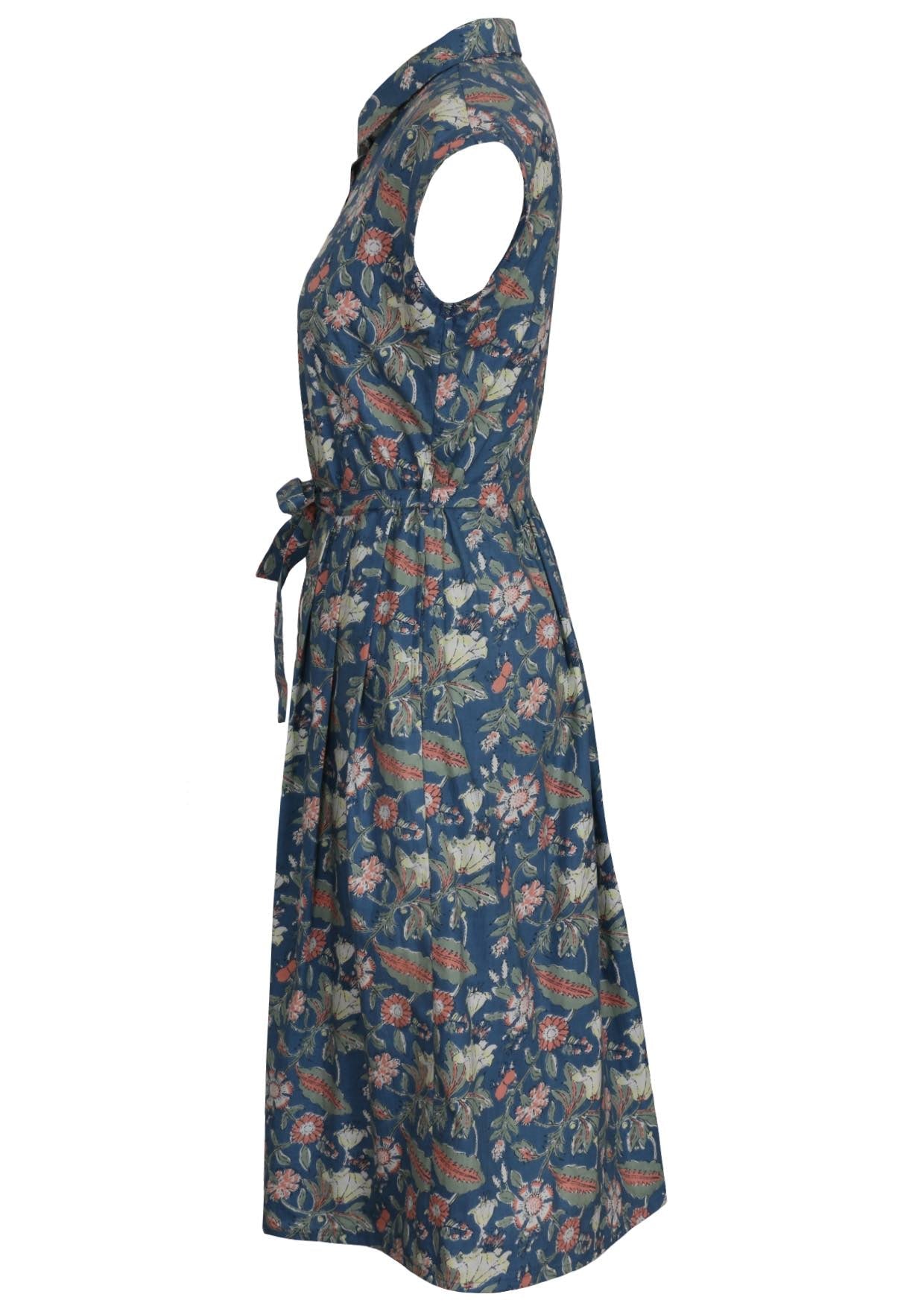 Side view of dusty blue floral cotton dress with cap sleeves, collar, hidden side pocket and box pleats at front waist