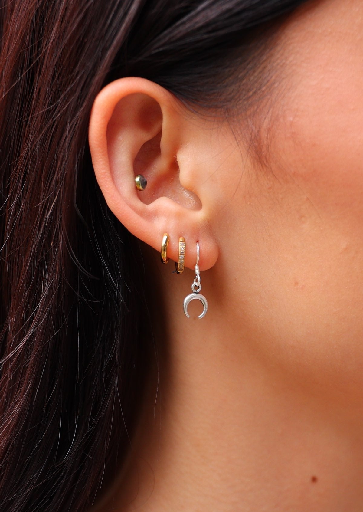 Close up of little sterling silver crescent moon hook earring