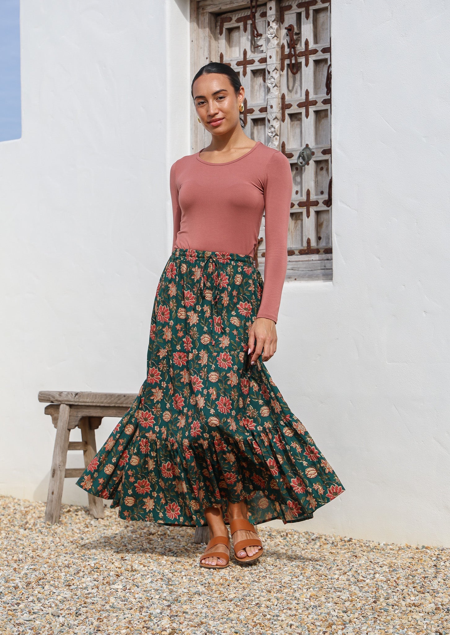 Model pairing a 100% cotton floral printed maxi skirt in deep green with a long sleeve stretch top in dusty pink.