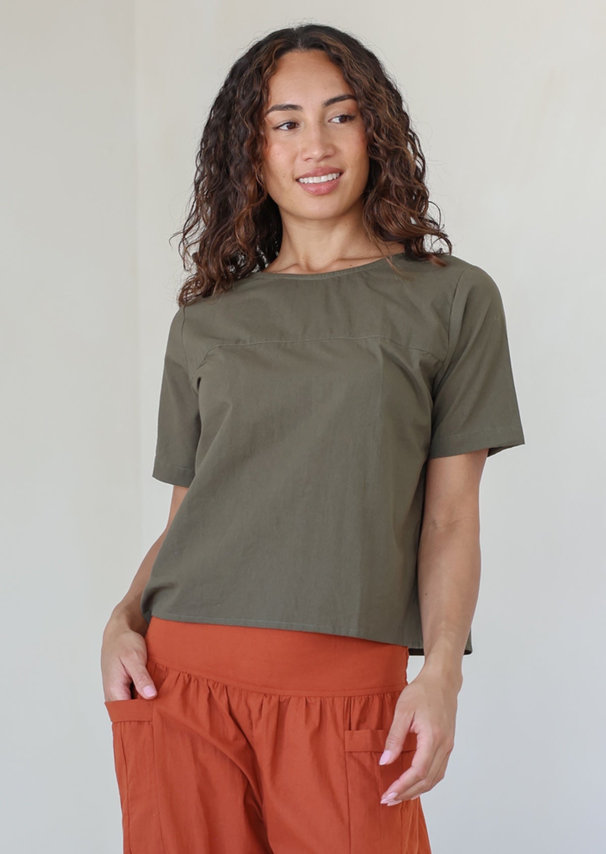 Model wearing a 100% cotton top in olive green shade paired with a rust pants