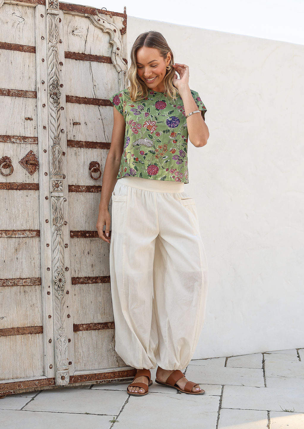 Models poses in white cotton wide leg pants with elasticated ankle