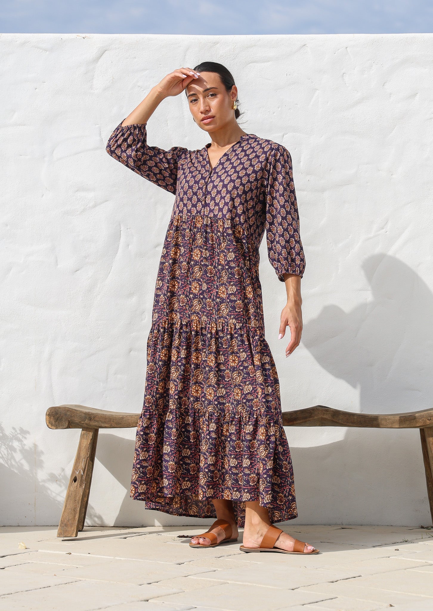Model wears dark purple based floral cotton dress with pockets, 3/4 sleeves, V neck and mandarin collar.