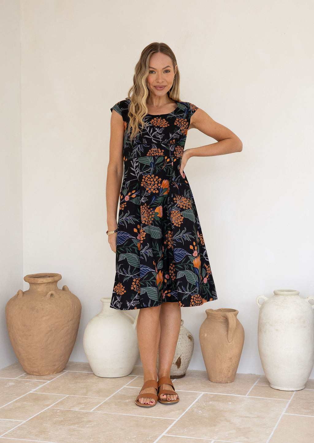 Model in knee length, black 100 percent cotton scoop neck retro style dress with pockets and cap sleeves