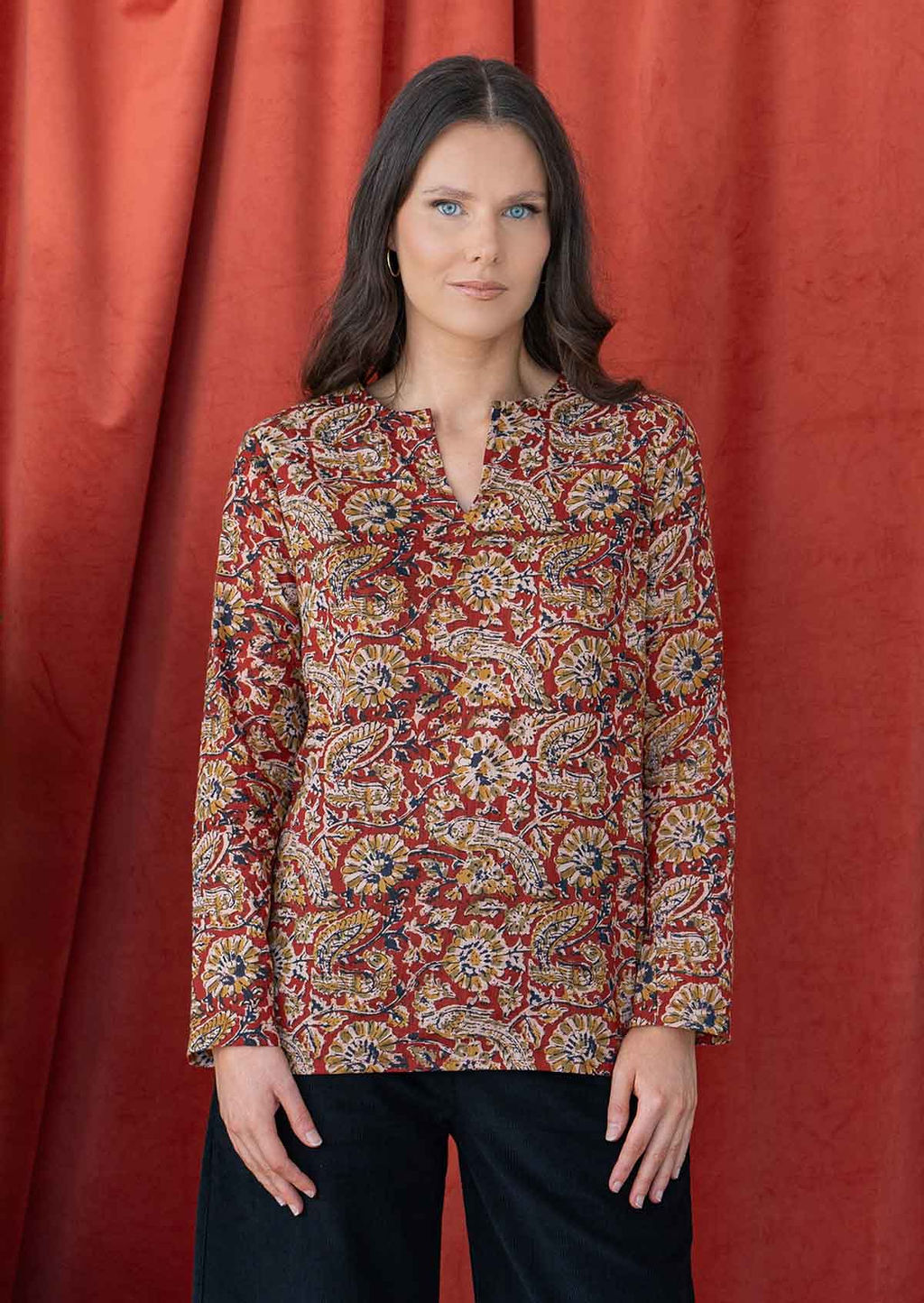 Model wears cotton long sleeve top with keyhole cutout and round neckline in a rusty indian floral print.