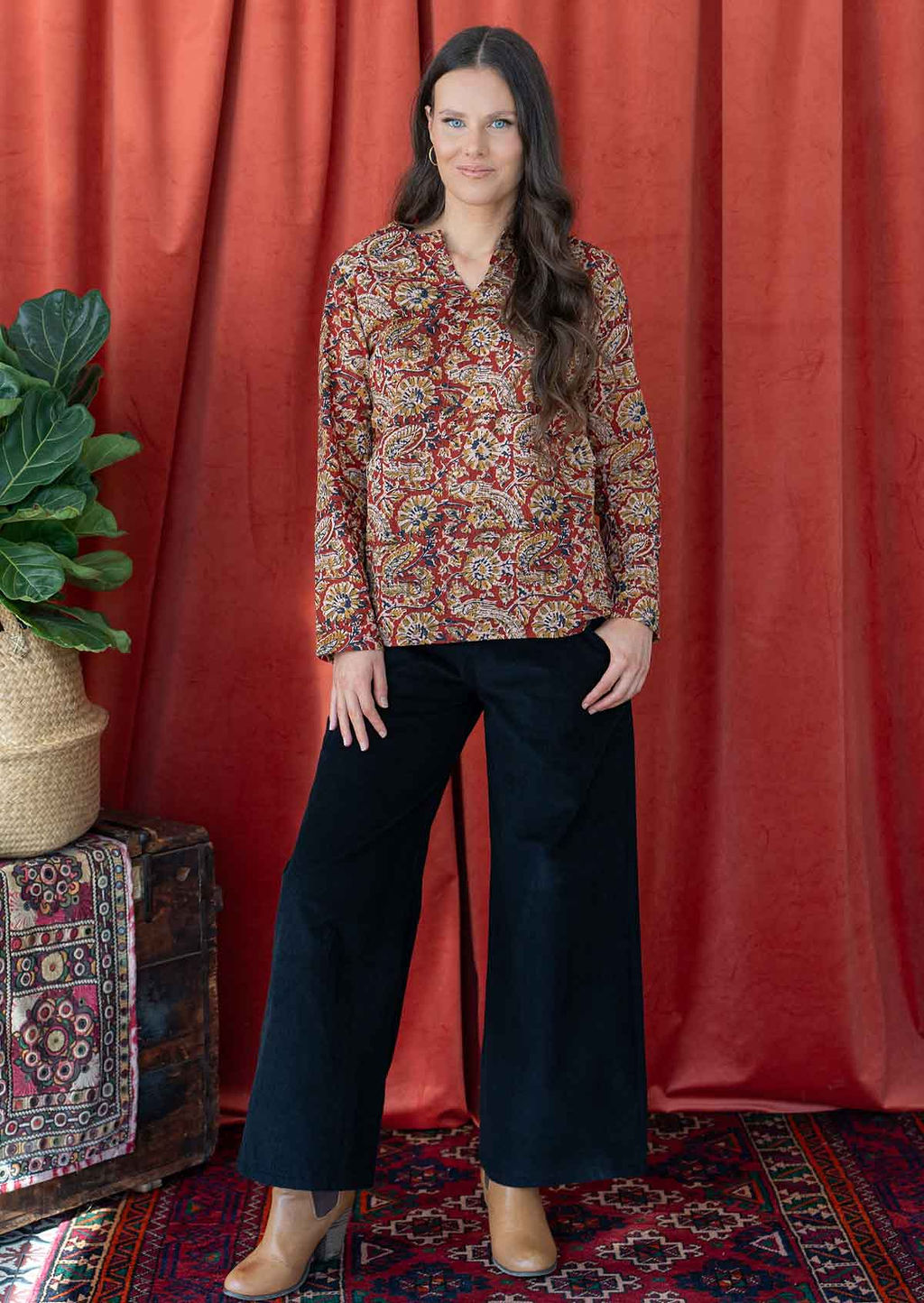 Model pairing a 100% cotton long sleeve top with round neckline and V cutout, beautifully paired with black corduroy pants.