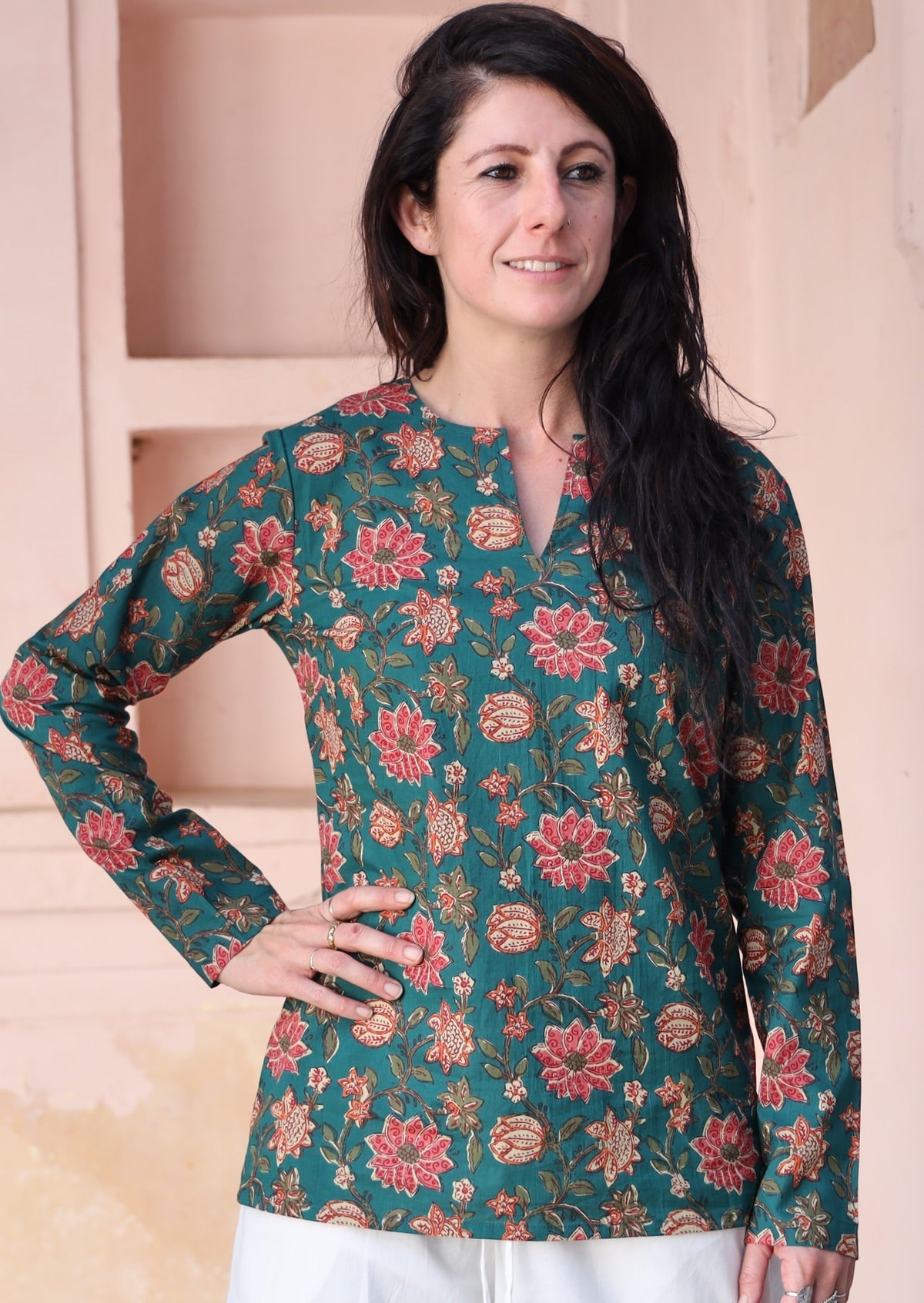 Model poses in cotton long sleeve top with keyhole cutout, in a green based floral print