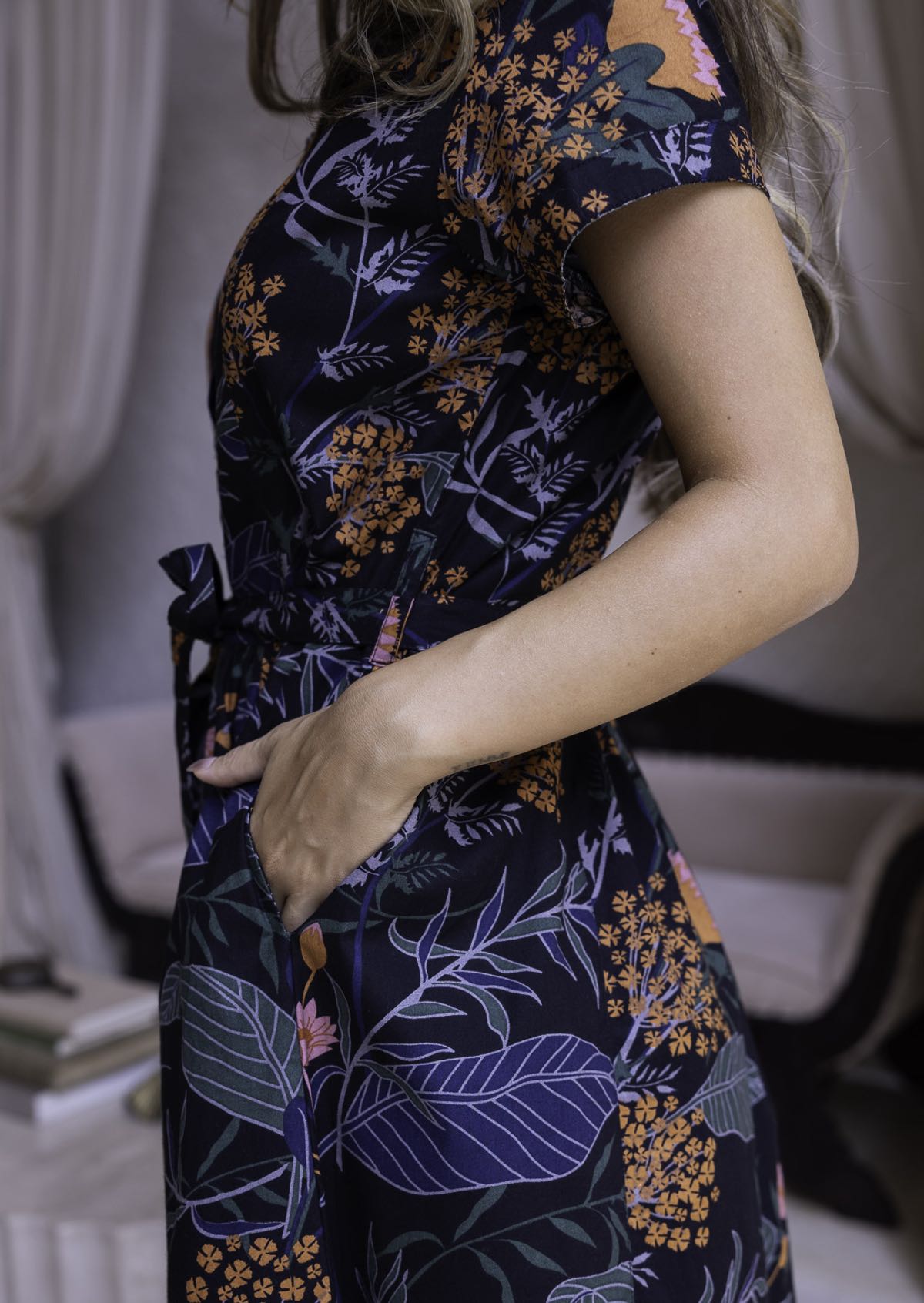 100 percent cotton short sleeved dress with pockets and a fabric waist tie in black based retro botanical print.