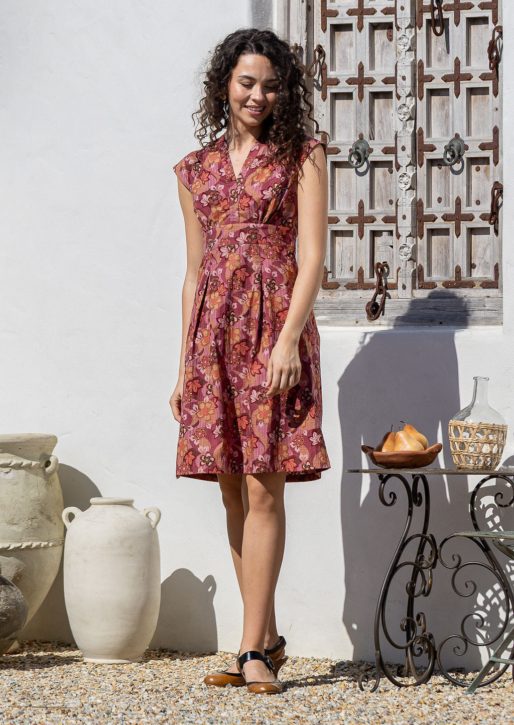 Woman wearing Japanese style floral print cotton dress with cap sleeves, box pleats and V neckline