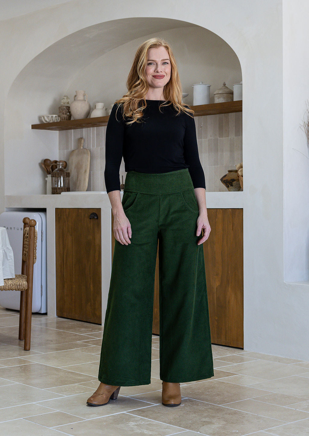 Woman wearing a cotton corduroy wide leg pants in olive green paired with a basic black top.