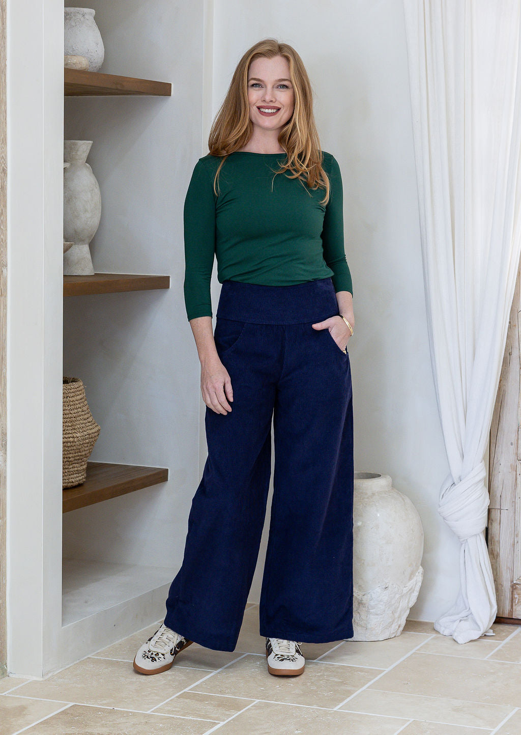 Woman in green basic top and blue cotton corduroy wide leg pants with wide waistband and pockets