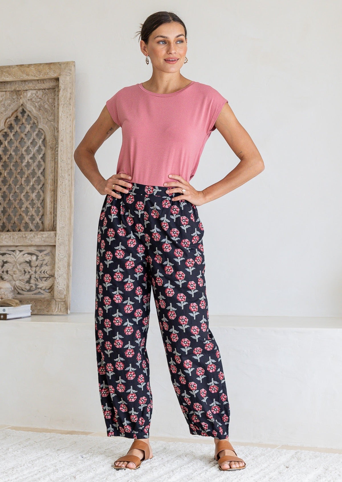 Woman wearing a basic pink top and black floral print wide-leg pants, 100% cotton.