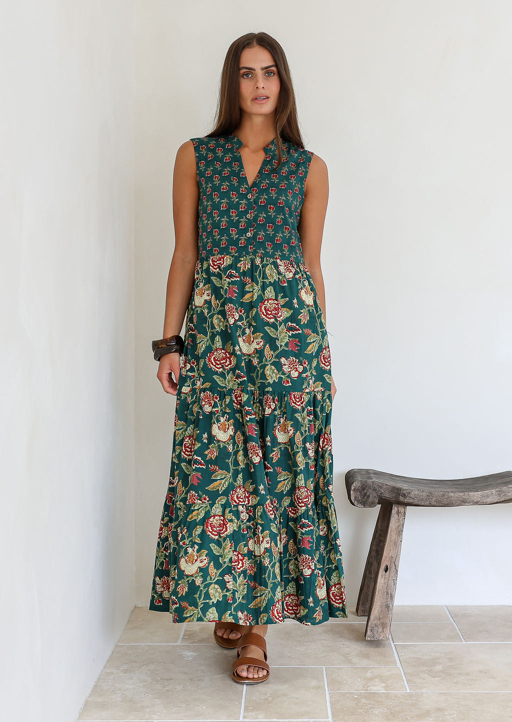 Model wears bottle green based floral cotton dress with pockets, 3/4 sleeves, V neck and mandarin collar.