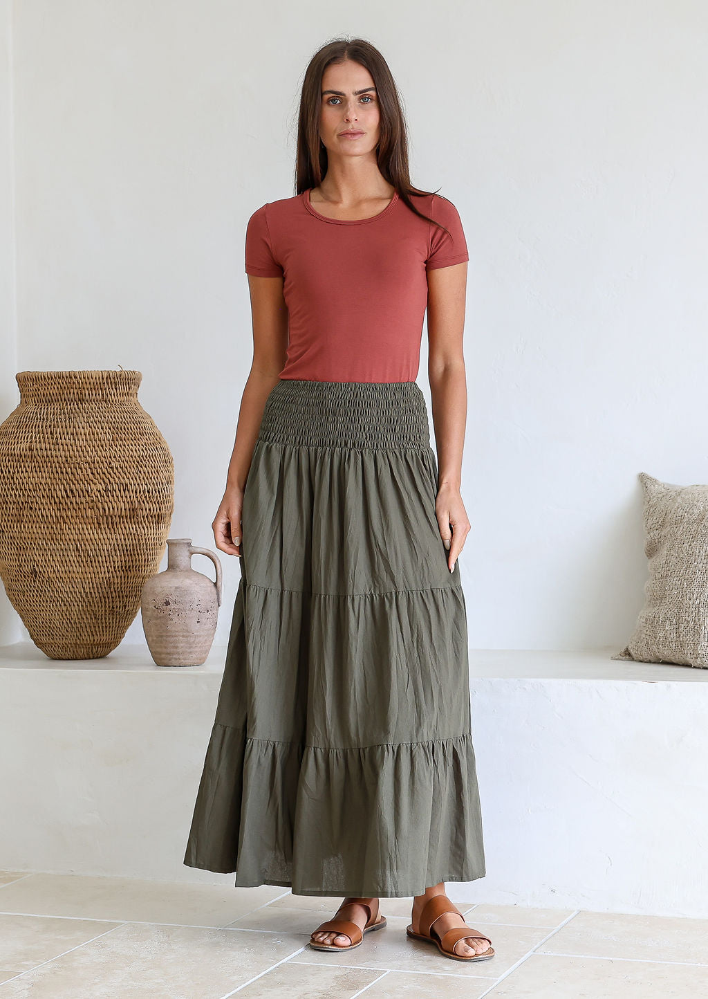 Model is wearing 100% cotton tiered maxi skirt in olive green shade with wide elasticated waistband.