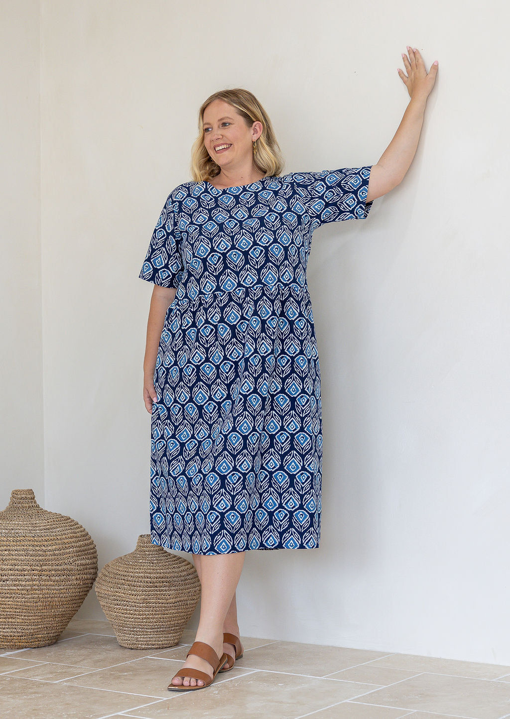 Woman wearing a 100% cotton relaxed fit dress with round neckline.