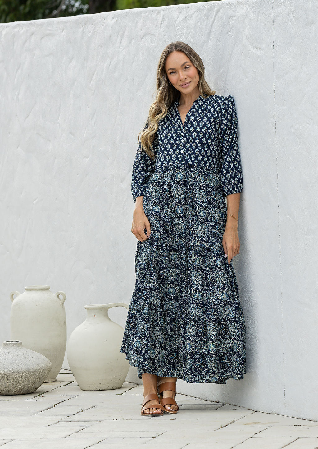 Woman wearing a 100% cotton tiered maxi dress in floral print with 3/4 sleeves, pockets and mandarin collar