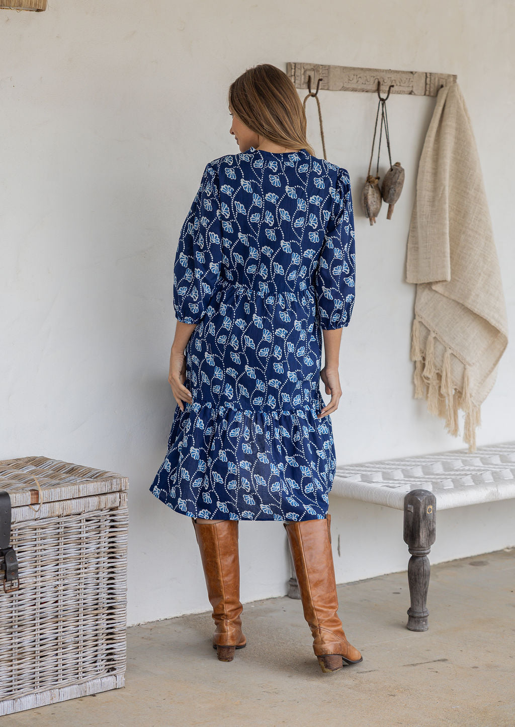 Model stands backwards on in cotton over the knee length relaxed fit dress with 3/4 sleeves, paired with brown boots.
