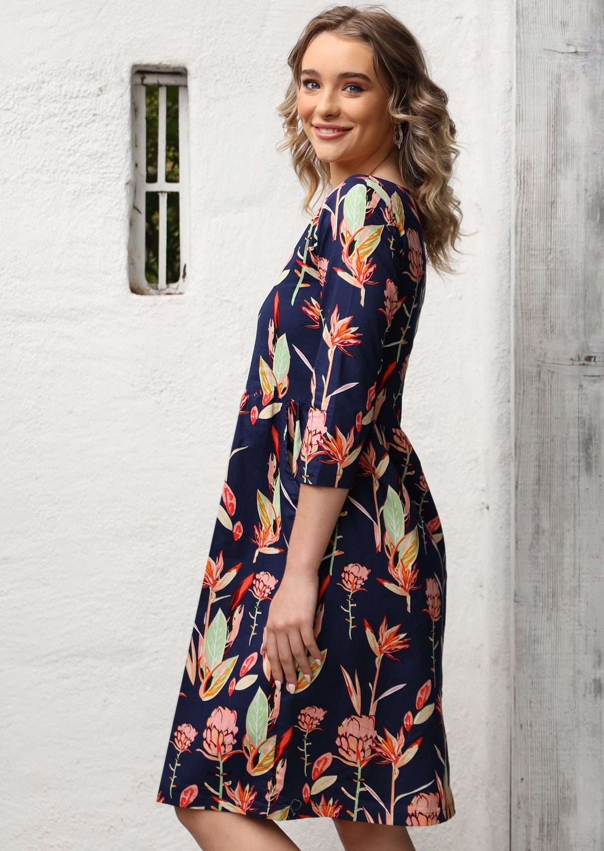 Model wears 100% cotton 3/4 sleeves dress with pockets and wide round neckline.