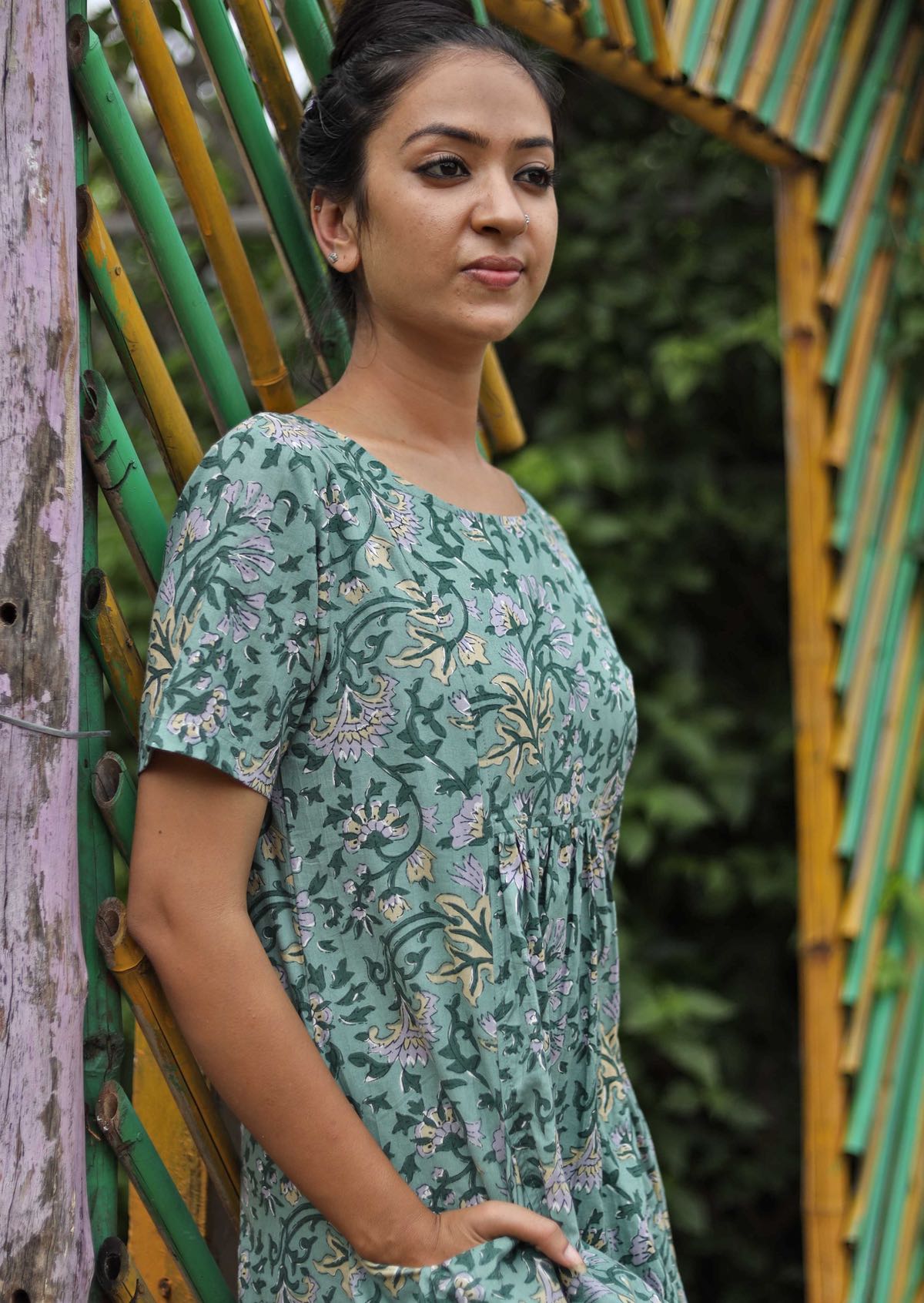 Model wearing round neck short sleeve dress with hands in pocket