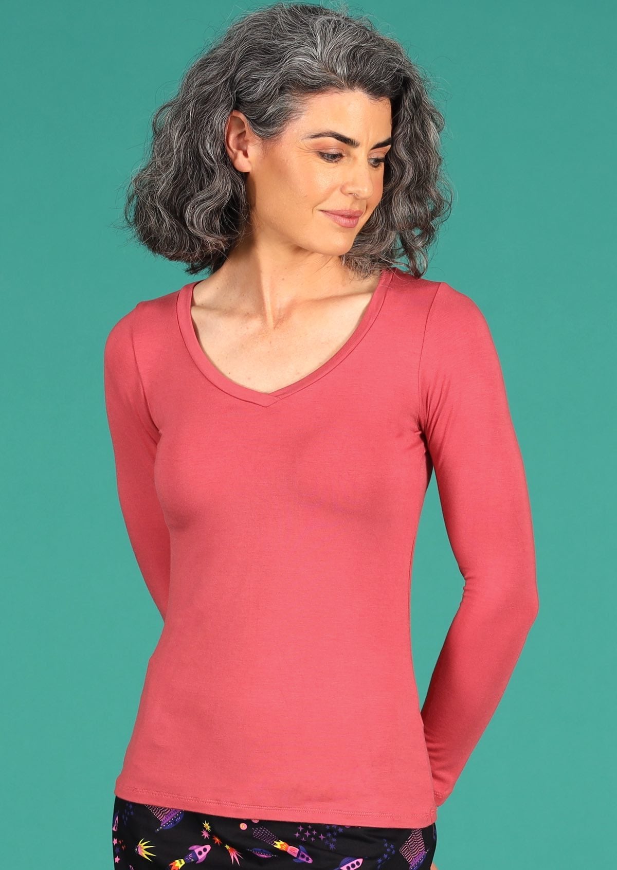 Woman wearing a rose pink long sleeve stretch v-neck soft rayon top.