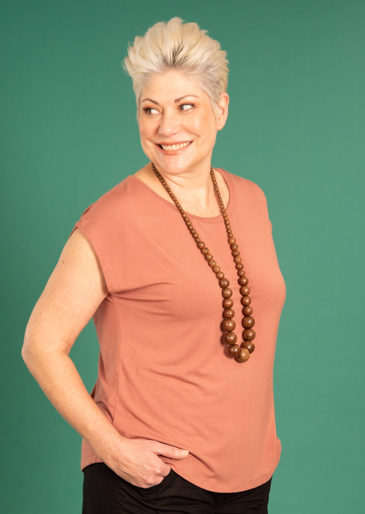 Woman with short blonde hair wearing a soft flattering fit dusty pink rayon jersey t-shirt.