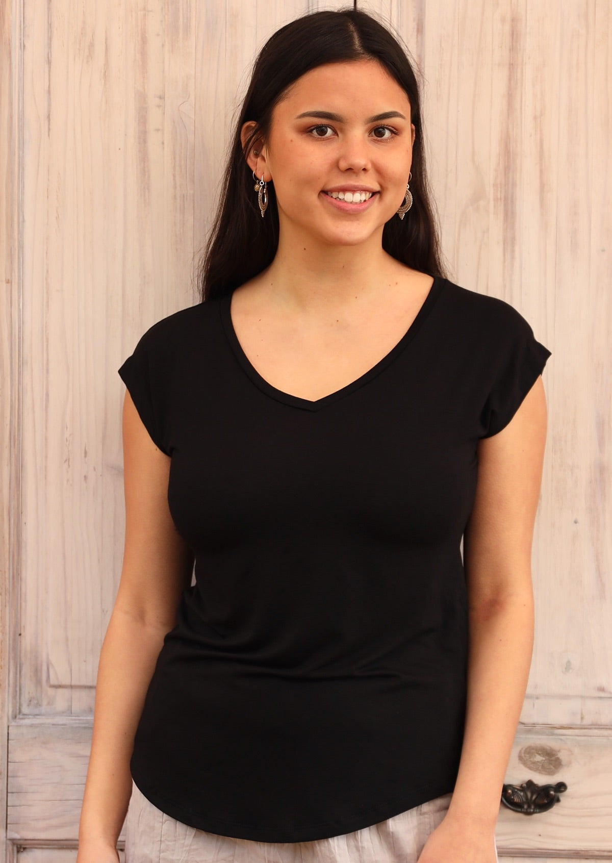 Woman wearing a black v-neck short cap sleeve rayon top
