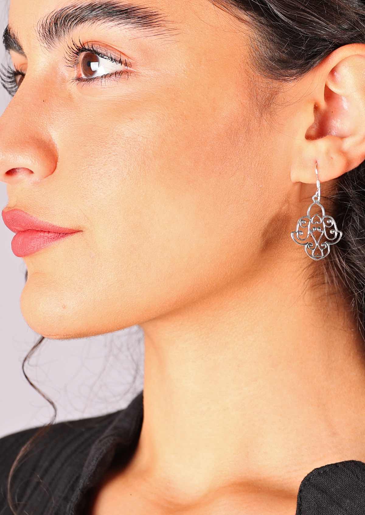 Sterling silver earrings featuring a delicate filigree window, suspended from wire hooks
