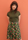 Model wears Aalia Skirt Oak green, orange and white speckled botanical print on black base 100% cotton, knee length A-line skirt with side zip and pockets | Karma East