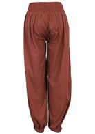 Back view of rust-colored lightweight cotton pants with cuffed ankles, shirred back waistband and pockets 