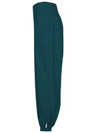 Side view of relaxed fit cotton pants with shirring at back of the waist, pockets and cuffed ankles with buttons